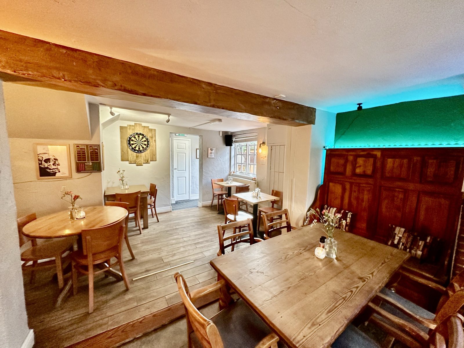 The Shakespeare Inn's dining room - oak beams, wooden tables and a dartboard on the wall.